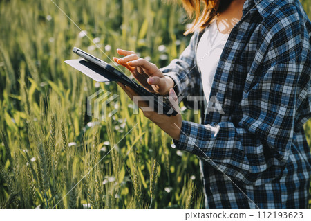 Smart farm. Farmer with tablet in the field. Agriculture, gardening or ecology concept. Harvesting. Agro business. 112193623