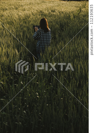 Smart farm. Farmer with tablet in the field. Agriculture, gardening or ecology concept. Harvesting. Agro business. 112193635