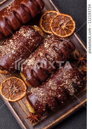 Delicious sweet chocolate cakes with fruit filling and sprinkles on a ceramic plate 112193734