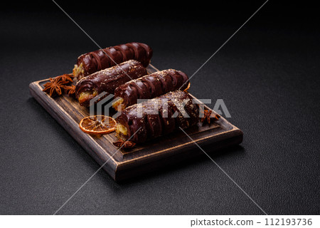 Delicious sweet chocolate cakes with fruit filling and sprinkles on a ceramic plate 112193736