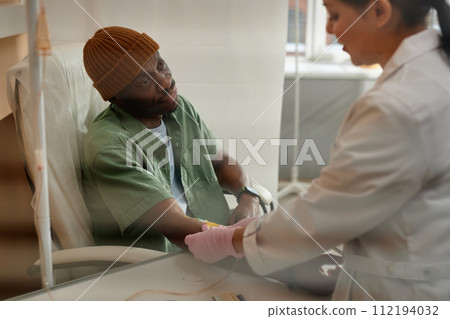 Portrait of African American man receiving chemotherapy treatment in procedure room at clinic behind glass copy space Portrait of African American man receiving chemotherapy treatment in procedure room at clinic behind glass copy space 112194032