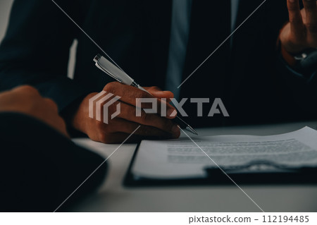 Justice and Law concept. Legal counsel presents to the client a signed contract with gavel and legal law or legal having team meeting at law firm in background 112194485