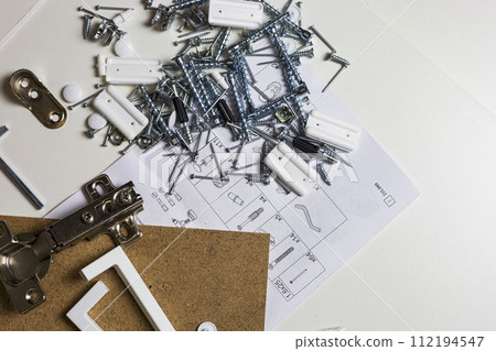 Furniture fittings. Furniture assembly hardware options and tools on a white background. 112194547