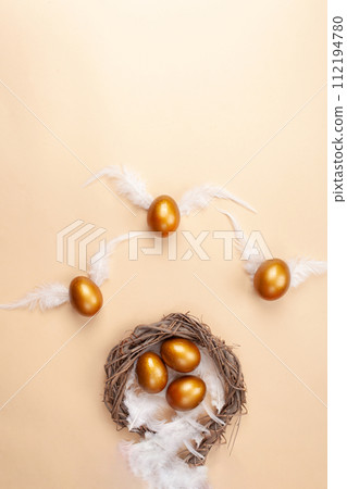 Empty space for text, a banner of happy Easter. Painted golden eggs, white feathers. copy space flat lay top view eggs with wings fly away from the nest Empty space for text, a banner of happy Easter. Painted golden eggs, white feathers. copy space flat lay top view eggs with wings fly away from the nest 112194780