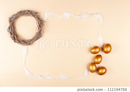 Empty space for text, a banner of happy Easter. Painted golden eggs, feathers. copy space flat lay top view Nest 112194788