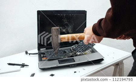 man destroyed laptop with a hammer. Nervous work, buggy computer, errors, slow Internet, not saved in the game, printed text, hung. Bad old computer failed, does not turn on, hangs. close up man destroyed laptop with a hammer. Nervous work, buggy computer, errors, slow Internet, not saved in the game, printed text, hung. Bad old computer failed, does not turn on, hangs. close up 112194793