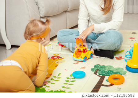 Mother and daughter play together, learn, home room, fun, love and care. A one year old girl. car. 112195592