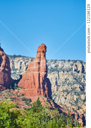 Sedona Red Rock Spire with Lush Greenery and Cliffs 112196129