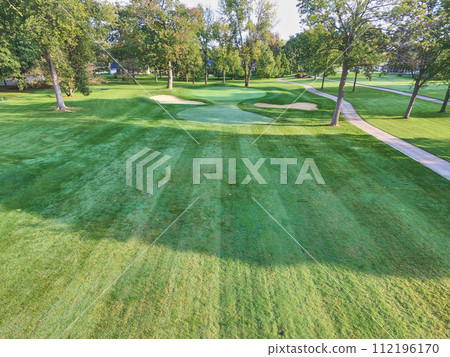 Aerial View of Serene Golf Course with Long Shadows and Lush Greens Aerial View of Serene Golf Course with Long Shadows and Lush Greens 112196170