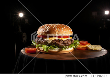 Juicy cheeseburger with fresh lettuce, tomato, and cheese on a toasted bun. Juicy cheeseburger with fresh lettuce, tomato, and cheese on a toasted bun. 112196315