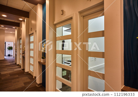 Modern Office Corridor with Frosted Glass Doors and Orchids 112196333