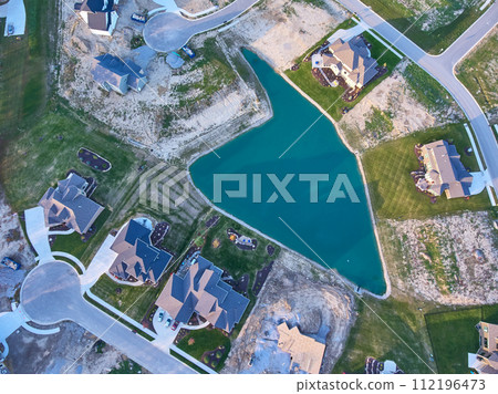 Aerial Top Down of Suburban Expansion by Blue Water in Fall 112196473