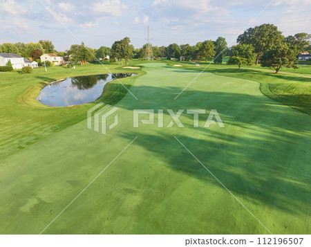 Aerial View of Serene Suburban Golf Course with Water Hazard and Mature Trees 112196507