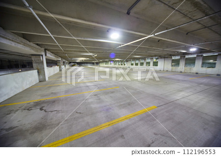 Deserted Urban Parking Garage with Fluorescent Lighting, Wide-Angle View Deserted Urban Parking Garage with Fluorescent Lighting, Wide-Angle View 112196553