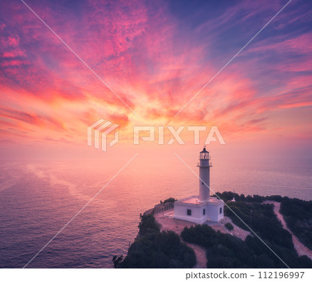 Lighthouse on the mountain peak at colorful sunset in summer 112196997