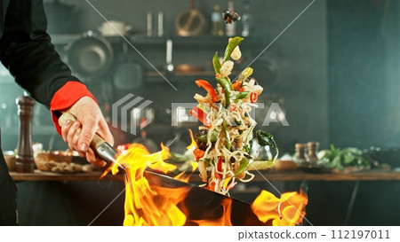Freeze Motion of Wok Pan with Flying Asian Meal in the Air. 112197011