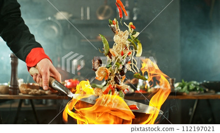 Freeze Motion of Wok Pan with Flying Asian Meal in the Air. 112197021