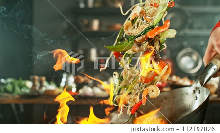 Freeze Motion of Wok Pan with Flying Asian Meal in the Air. 112197026