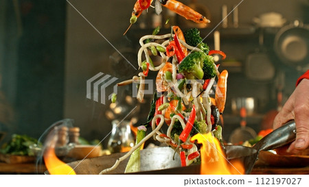 Freeze Motion of Wok Pan with Flying Asian Meal in the Air. 112197027