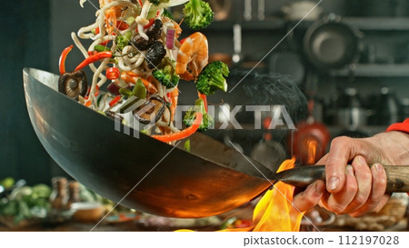 Freeze Motion of Wok Pan with Flying Asian Meal in the Air. 112197028
