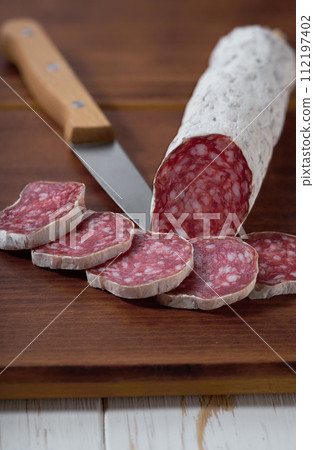 Spanish salami fuet sausage on a kitchen table, selective focus. 112197402