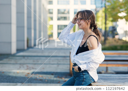 Successful beautiful business woman in suit with document walking to the meeting near modern office building. Successful beautiful business woman in suit with document walking to the meeting near modern office building. 112197642