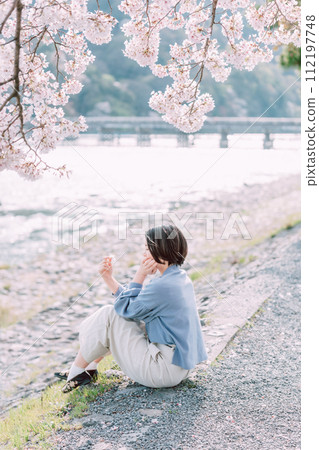 A woman sightseeing a famous cherry blossom spot 112197748