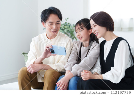 Family watching videos on smartphone Family watching videos on smartphone 112197759