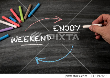 Enjoy your Weekend. Black scratched textured chalkboard background 112197838