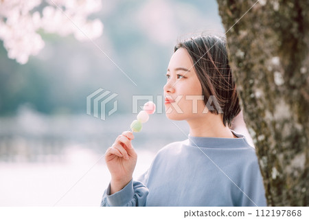 一個女人在賞櫻花時吃餃子 112197868