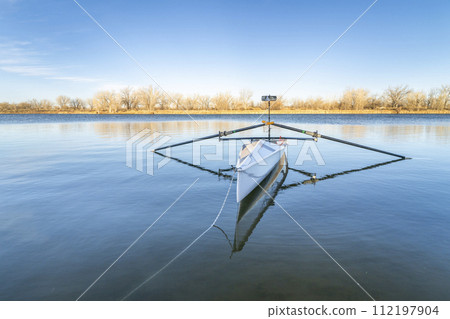 Coastal rowing shell by on a lake in northern Colorado in winter or early spring scenery. Coastal rowing shell by on a lake in northern Colorado in winter or early spring scenery. 112197904