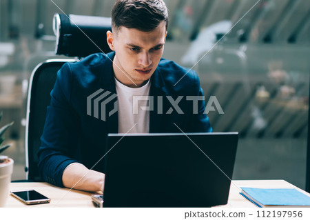 concentrated man in formal wear watching important webinar via netbook concentrated man in formal wear watching important webinar via netbook 112197956