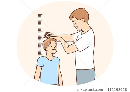 Smiling father measure son height near wall Smiling father measure son height near wall 112198628