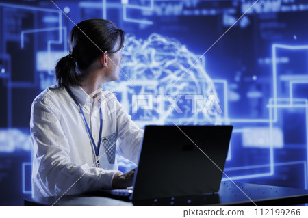 Qualified developer in data center using artificial intelligence computing simulating human brain through self learning algorithms. Skilled worker holding laptop, working with AI deep neural networks Qualified developer in data center using artificial intelligence computing simulating human brain through self learning algorithms. Skilled worker holding laptop, working with AI deep neural networks 112199266