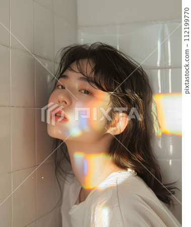 Wearing a curtain of light: Asian women pondering in the rainbow glow Wearing a curtain of light: Asian women pondering in the rainbow glow 112199770