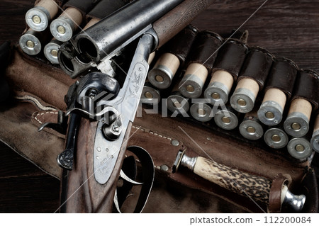 double barreled side shotgun with cartridges in bandolier. double barreled side shotgun with cartridges in bandolier. 112200084