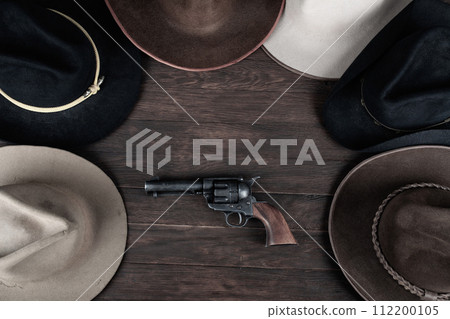 Gun with old west hats on table. Top view. Gun with old west hats on table. Top view. 112200105