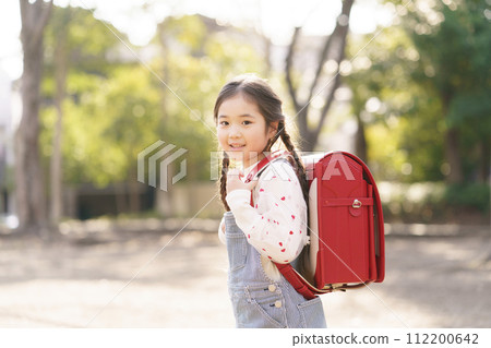 Elementary school student carrying a school bag Elementary school student carrying a school bag 112200642