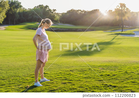 Energetic pregnant woman takes her workout outdoors, using an exercise mat for a refreshing and health-conscious outdoor exercise session 112200823