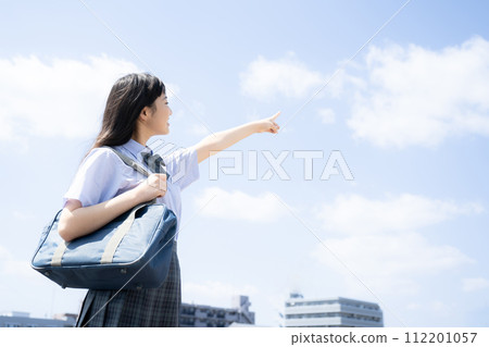 A student pointing with the blue sky on the rooftop, which is easy to use as an image for summer courses, entrance exams, etc. 112201057