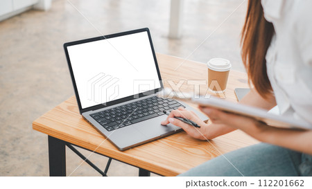 Close-up back view of a business woman working in the office typing, looking at the screen. office worker using a notebook computer.. 112201662