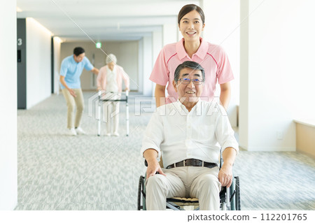 Senior in wheelchair and caregiver 112201765