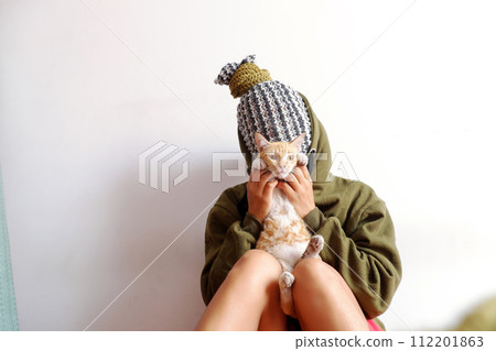 woman that head cover scarf, look like pineapple, hold cat in hand with old big book woman that head cover scarf, look like pineapple, hold cat in hand with old big book 112201863