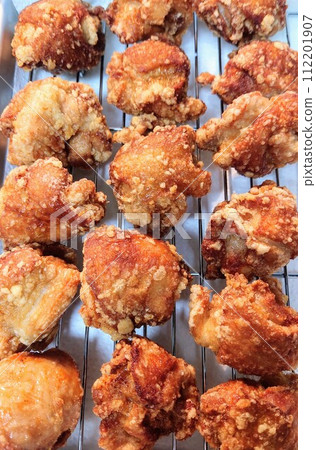 Freshly fried chicken lined up in a vat Freshly fried chicken lined up in a vat 112201907