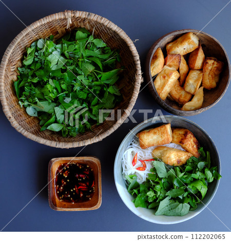 vegan Vietnamese meal, simple homemade food, bun with fried tofu, soy sauce and herbal leaf vegan Vietnamese meal, simple homemade food, bun with fried tofu, soy sauce and herbal leaf 112202065