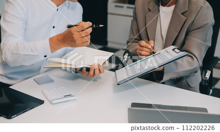 Business team working with new startup project plan and discussion information for financial strategy with laptop and digital tablet in a modern business lounge. 112202226