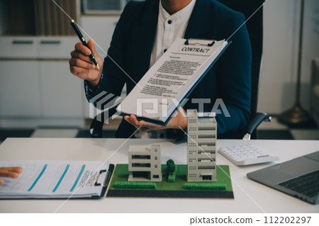 Real estate agent talked about the terms of the home purchase agreement and asked the customer to sign the documents to make the contract legally, Home sales and home insurance concept. 112202297