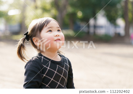 Little girl playing in the park 112202402