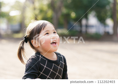 Little girl playing in the park 112202403