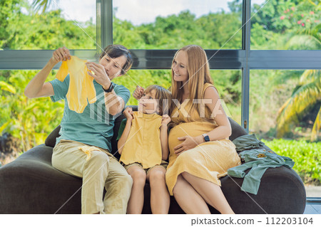 Heartwarming family moment as expectant mom, dad, and son joyfully browse through newborn baby's clothes, eagerly anticipating the arrival of a new family member Heartwarming family moment as expectant mom, dad, and son joyfully browse through newborn baby's clothes, eagerly anticipating the arrival of a new family member 112203104